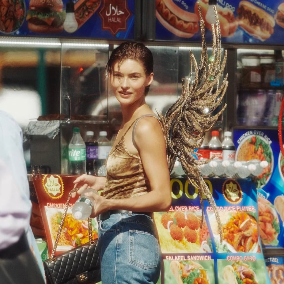 model in jeans and gold wings on the street