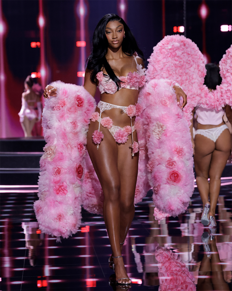 Angel Reese walks down the runway in a flowery bra-and-panty set with a matching pink boa draped around her at the 2025 Victoria’s Secret Fashion Show.
