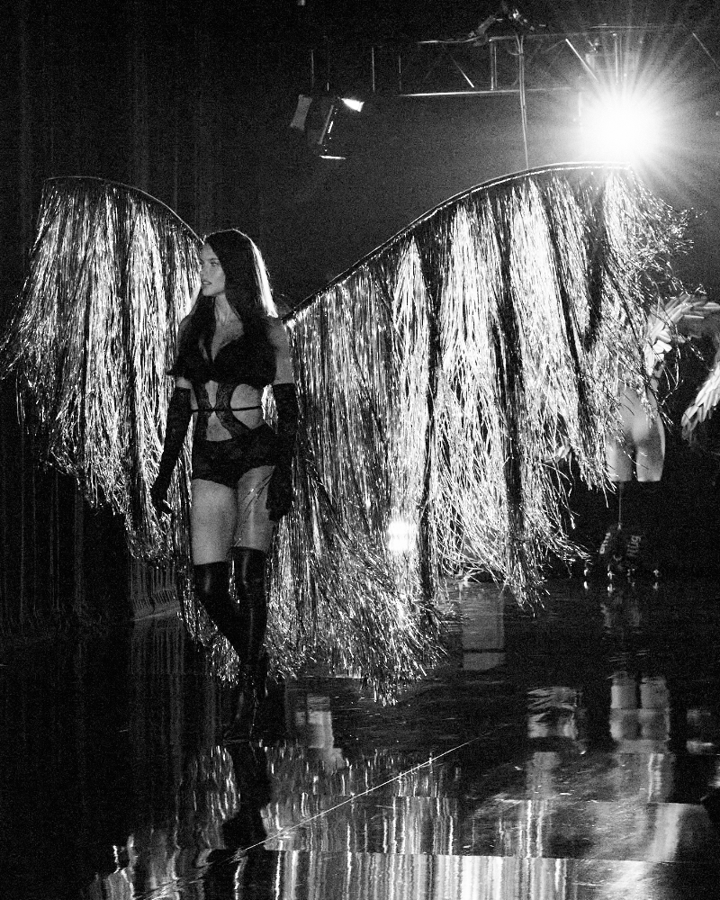 Adriana Lima walks in a black lingerie set and silver, tassel wings at the 2025 Victoria’s Secret Fashion Show.