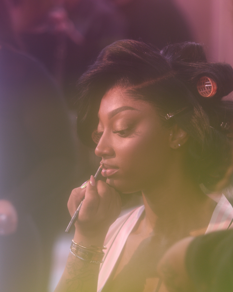 A makeup artist applies lip liner to Angel Reese as she gets runway-ready at the 2025 Victoria’s Secret Fashion Show.